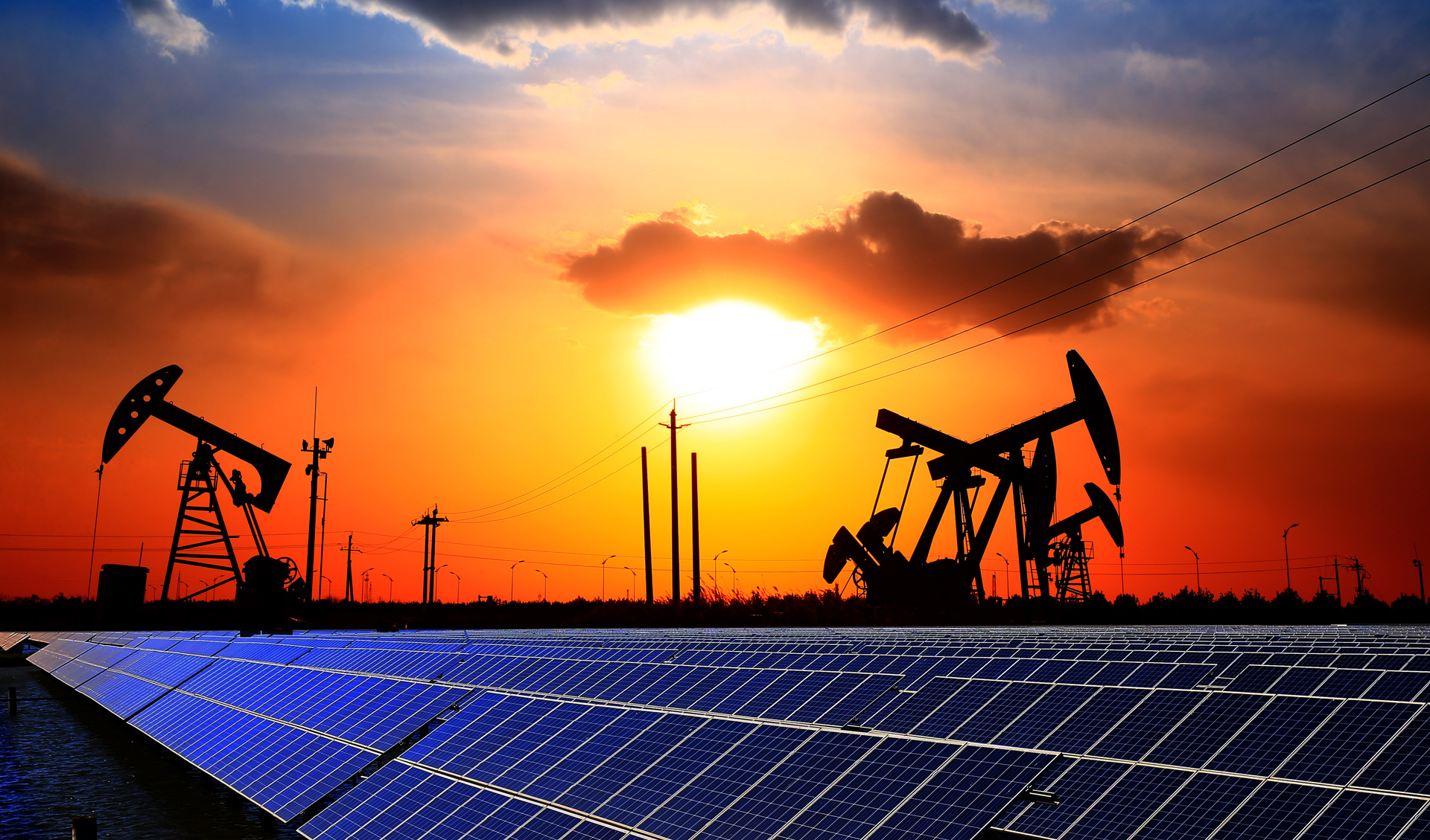 Oil pump with solar panels and the sunset