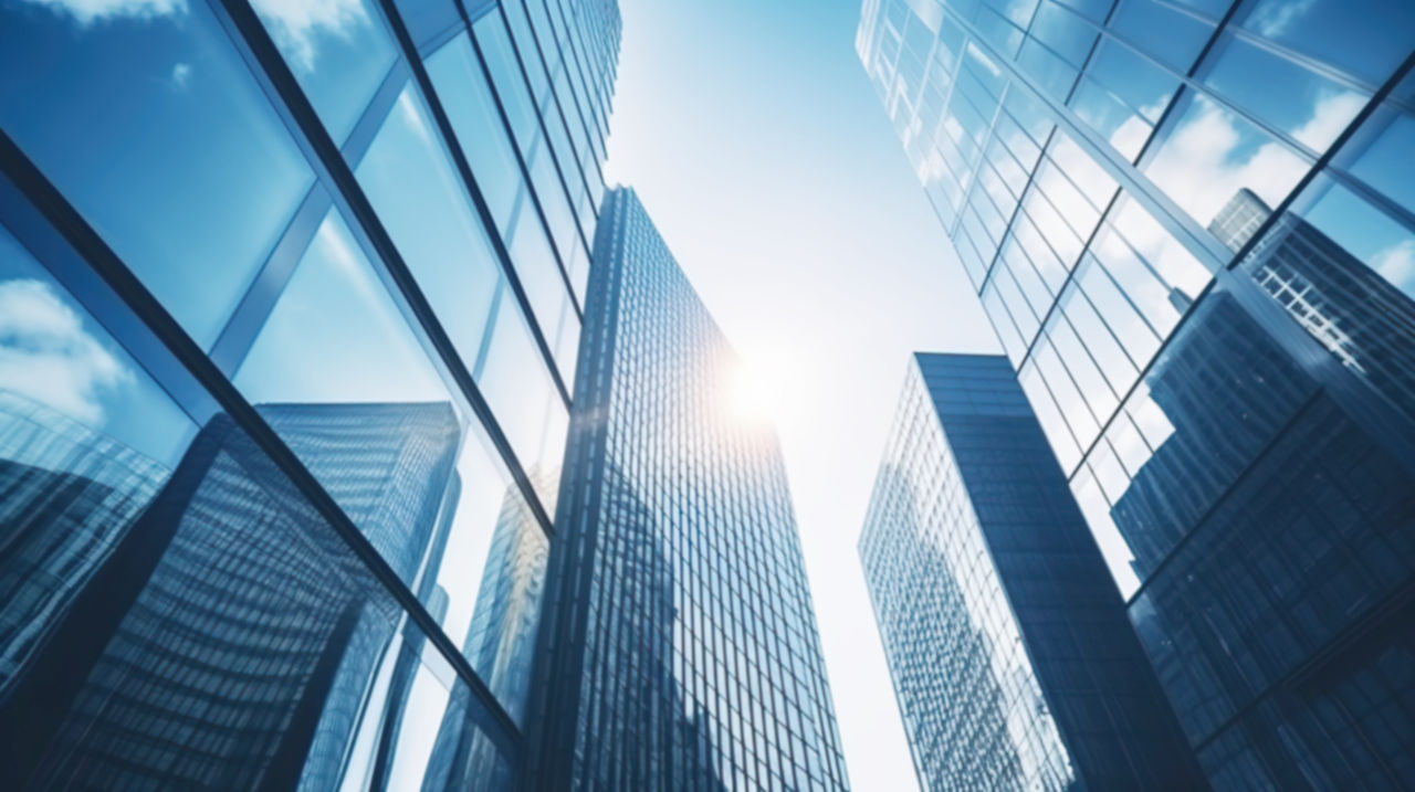 Modern office building with blue sky, and glass facades. Economy, finances, business activity concept, Bottom-up view, blurred image