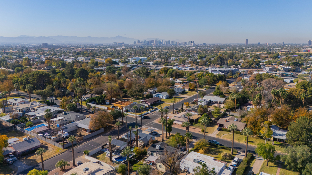 Aerial view of Phoenix suburb with skyline and mountains.