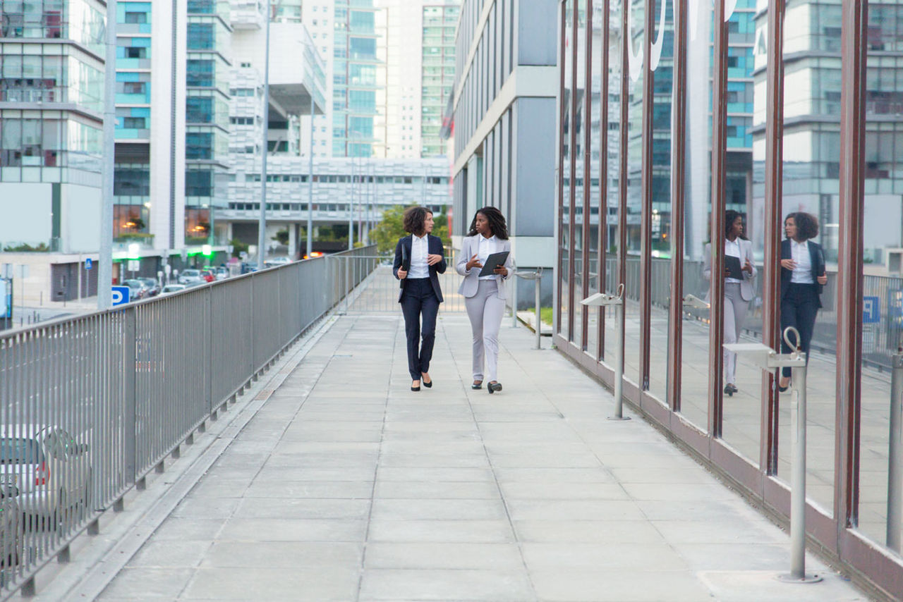 Professional businesswomen with folders on street