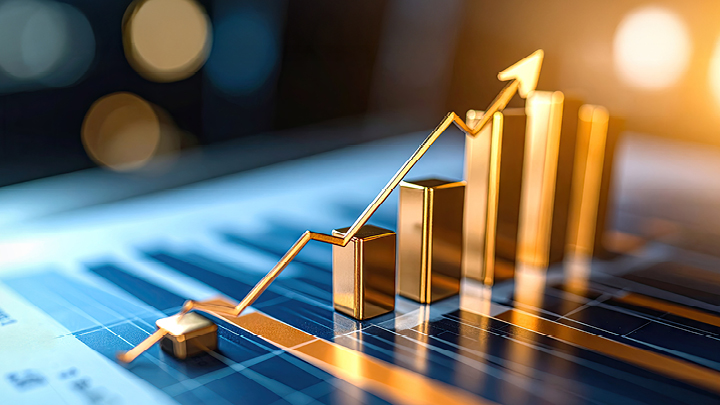 Golden bar chart with upward arrow emerging from financial report in warm lighting.